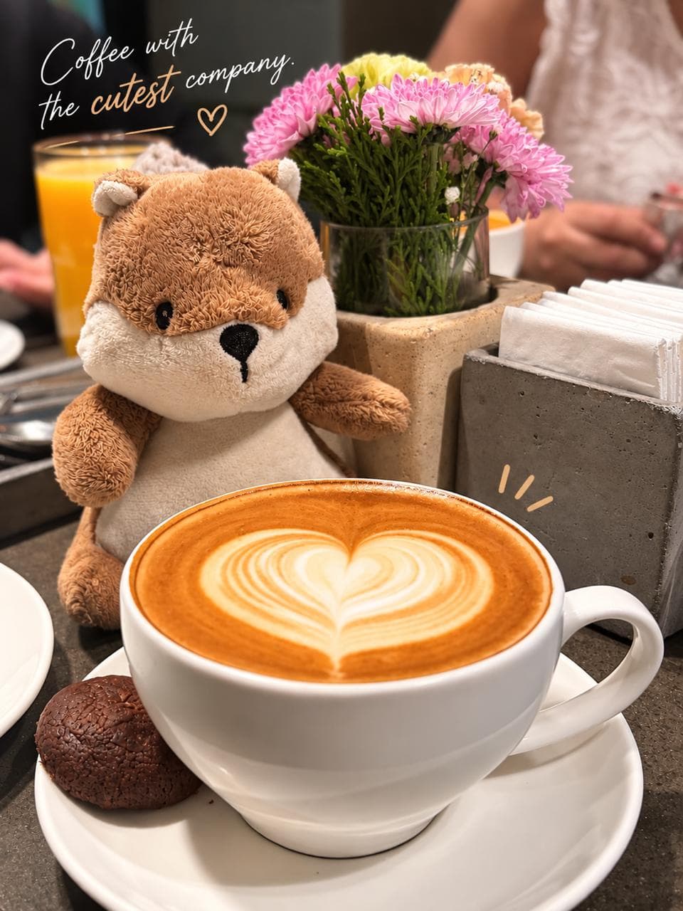 A cup of coffee on a wooden desk beside a notebook