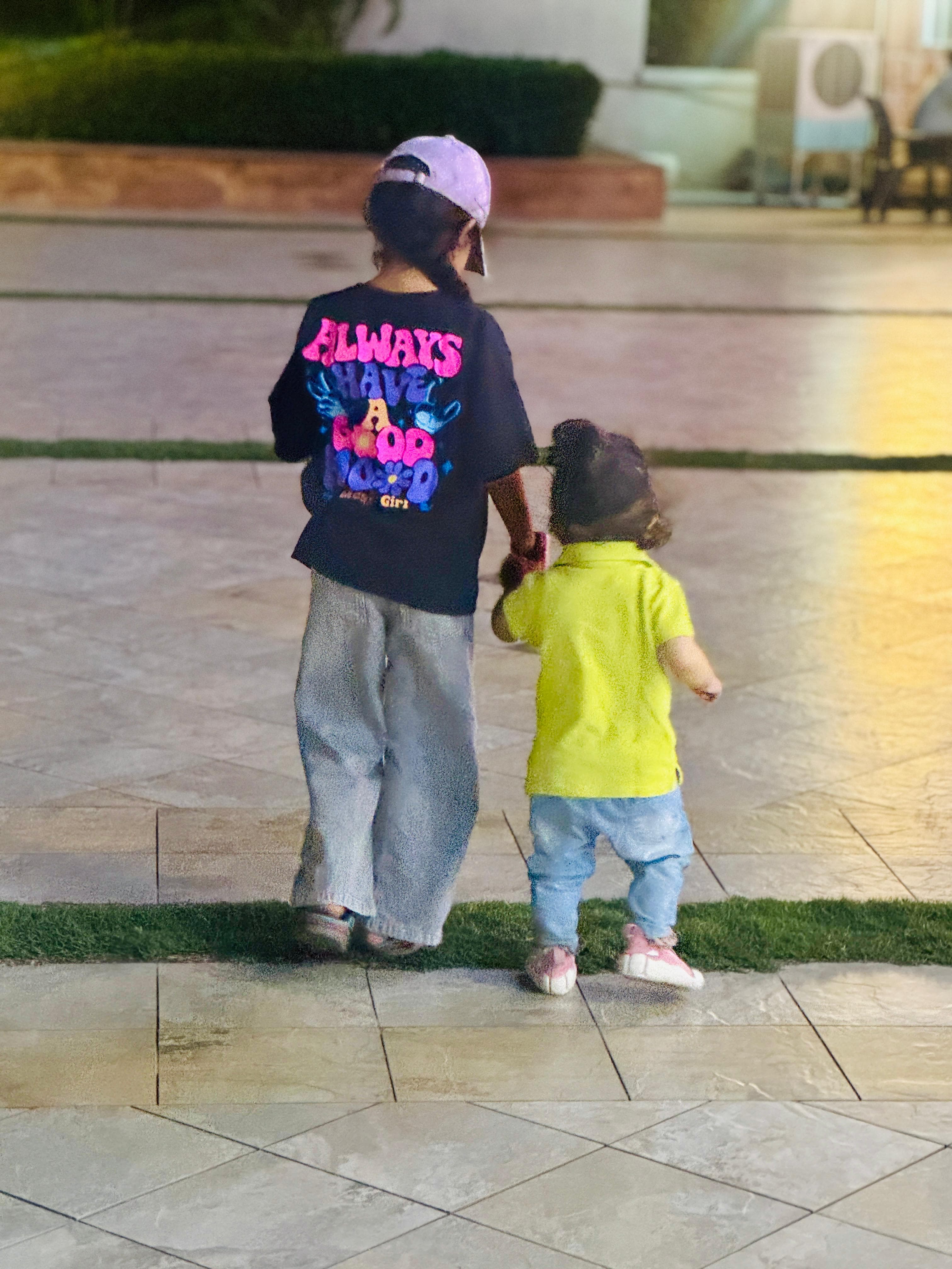Two children seen from behind, looking at string lights